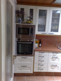 muebles de cocina blancos con columna horno y micro